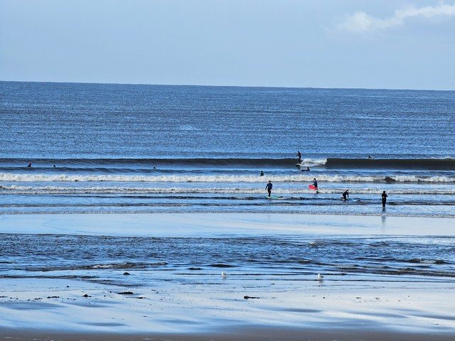 Longboarder riding a wave in the middle of the beach